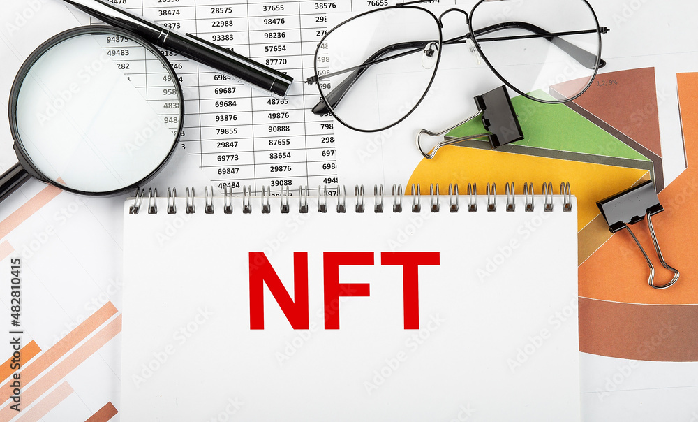 Text NFT on white paper notebook on the diagram. Business concept Text NFT on white paper notebook on the diagram. Business concept