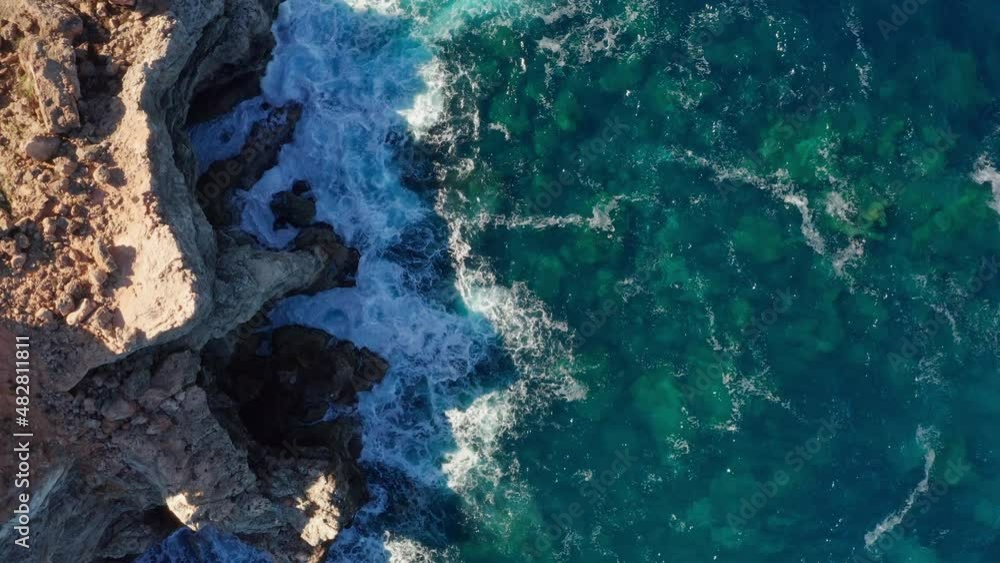 Aerial overhead view of mediterranean ocean waters pounding on cliffs in Ibiza. Aerial overhead view of mediterranean ocean waters pounding on cliffs in Ibiza.