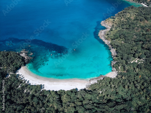 Top view of the exotic lagoon: narrow strip of the white sand framed with turquoise clear sea from one side and green tropical forest from another  paradise concept. © Semachkovsky 