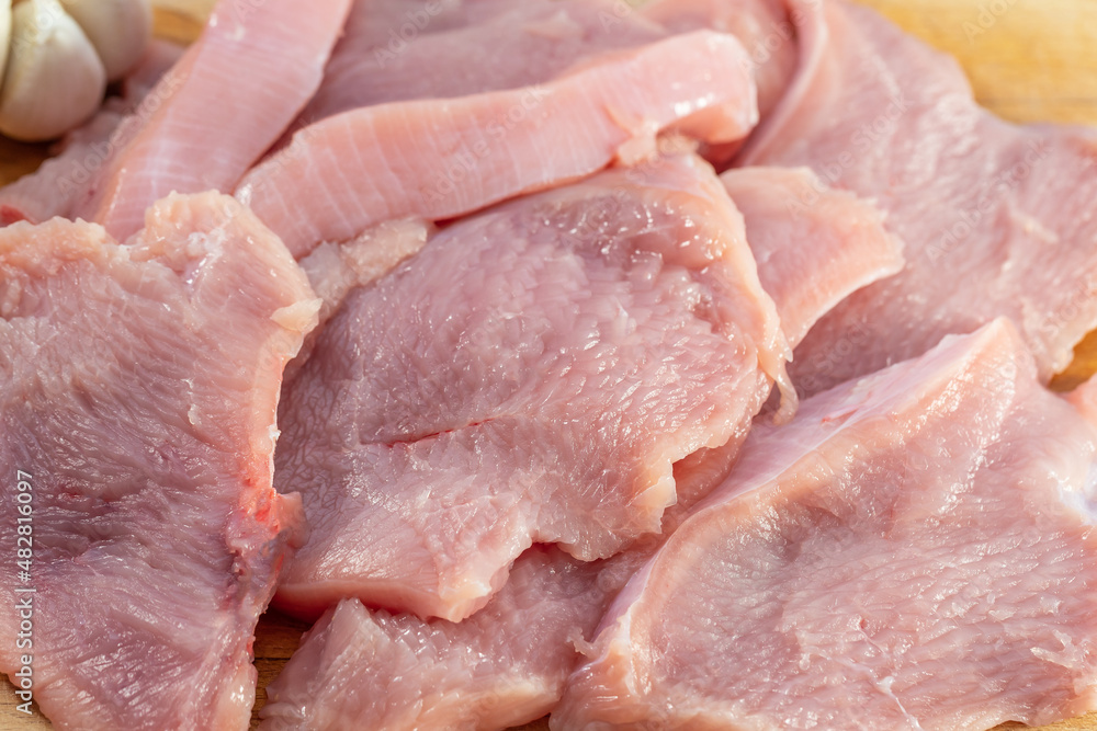 Raw meat. Sliced turkey breasts are on a wooden board. Raw meat. Sliced turkey breasts are on a wooden board.