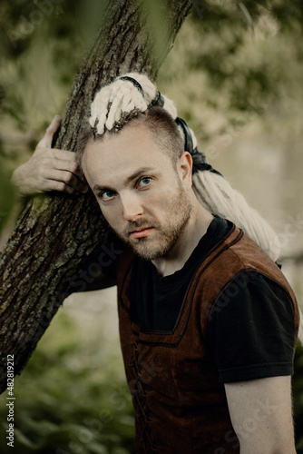 A porait of a young man with interesting depicts a viking looks to the camera photo