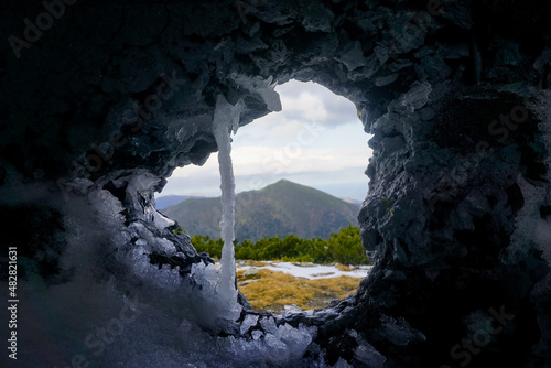 View of the mountain landscape through a hole in the wall