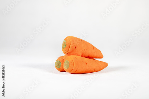 plush orange carrots on white background