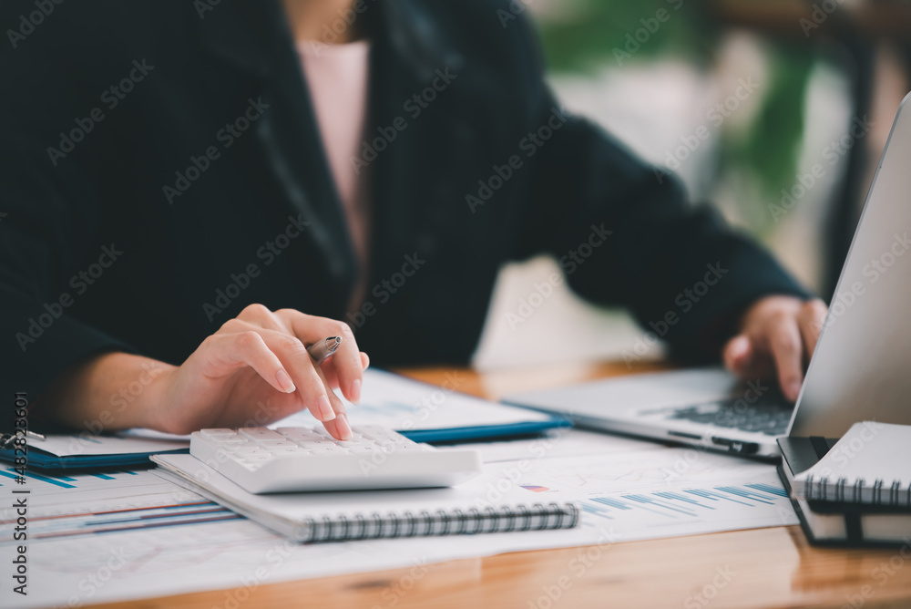 businessman or accountant who are using a calculator to calculate business data Accounting documents and laptop computer at the office business idea businessman or accountant who are using a calculator to calculate business data Accounting documents and laptop computer at the office business idea