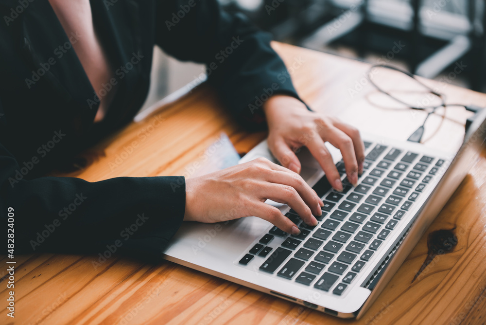 Close-up shot of a young woman typing on a keyboard. Close-up shot of a young woman typing on a keyboard.