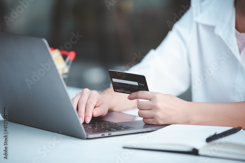 young woman holding credit card and using a laptop computer business woman working from home  online shopping  ecommerce  internet banking  spending money  finance  work from home concept..