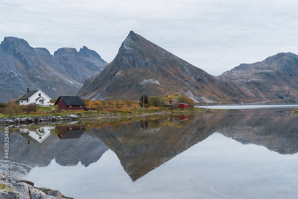 Norwegian lake with several houses and mountains in the background