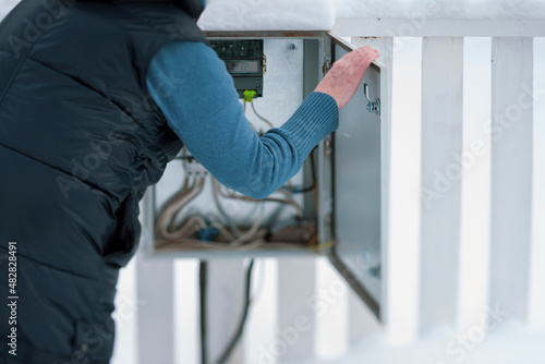 woman inspecting electric fuse box