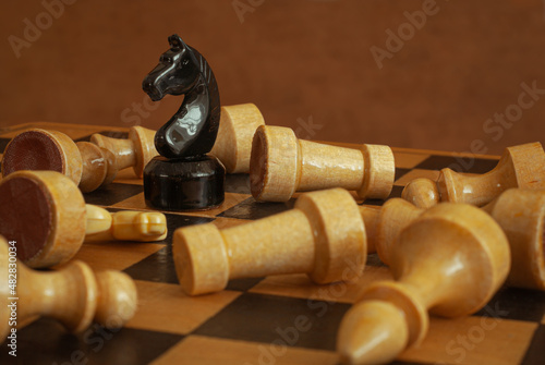 Be the winner concept. A wooden chess piece that is victorious. Last one standing amongst the fallen.