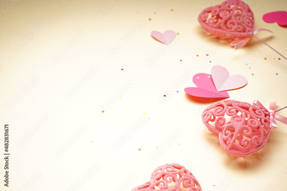 Fototapeta premium Pink hearts and confetti for Valentine's Day on yellow background, close up.