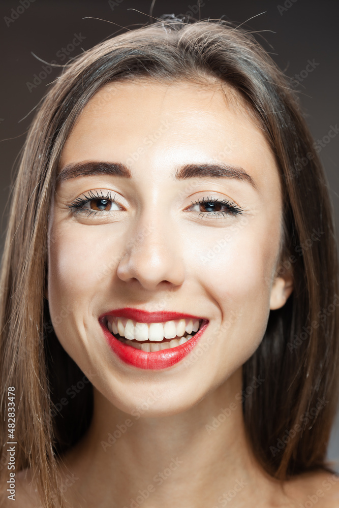 Beautiful brunette girl studio portrait. Smiling face expression.