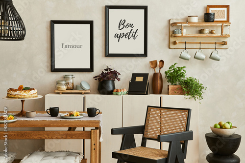 Creative and cozy kitchen interior composition with mock up poster frames, beige commode, plants, chair, family table and elegant accessories. Template. . © FollowTheFlow