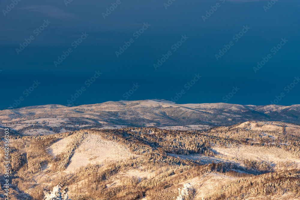 Nearer hills of Kysucke Beskydy and Beskid Sllaski on the backgrounf from Wielka Racza hill summit in winter Beskid Zywiecki mountains on polish - slovakian borders