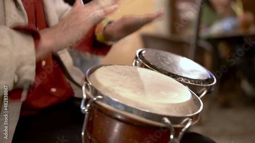 Person playing bongo drums at night