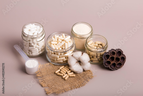 Nutritional supplements in beautiful composition from above in rustic style on light background. Organic food supplements for people. No gluten and lactose free vitamins and minerals. Flat lay food. 