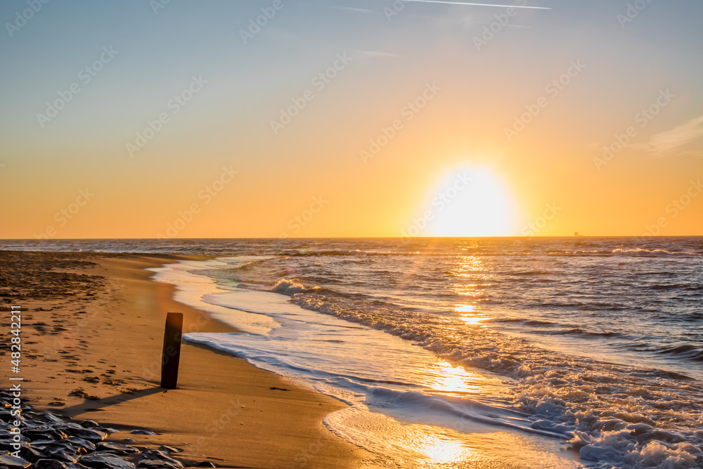 Den Helder, Netherlands. January 2022. Setting sun on the beach of Den Helder, Netherlands.