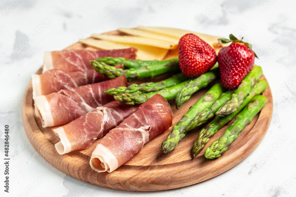 Antipasto platter. asparagus, jamon, ham, prosciutto, strawberries. ketogenic diet lunch concept. Keto Paleo diet menu, top view