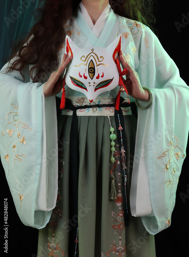 Woman wearing kimono, hanfu and a fox mask. Japanese, chinese traditional concept. Kitsune © Alex