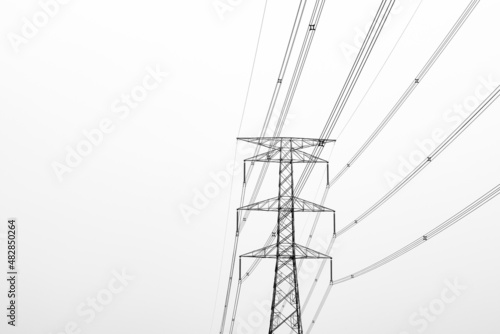 High voltage electricity transmission tower under the foggy sky in the evening with copy space