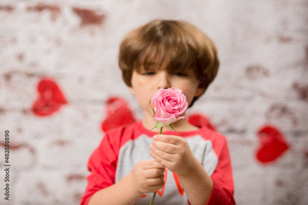 Boy small child posing for kisses for valentines day charging cute kid making faces being sweet. 