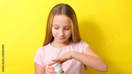 Teenage girl takes omega 3 capsules on a colored background close-up