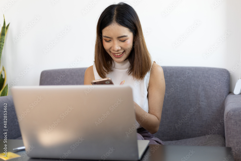 Asian woman working on laptop at home. Work from home and online shopping concept. Asian woman working on laptop at home. Work from home and online shopping concept.