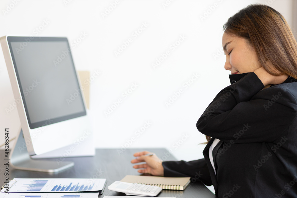 A business woman has a pain in the nape of her neck. Woman with neck pain from hard work doing stretching to relax. A business woman has a pain in the nape of her neck. Woman with neck pain from hard work doing stretching to relax.