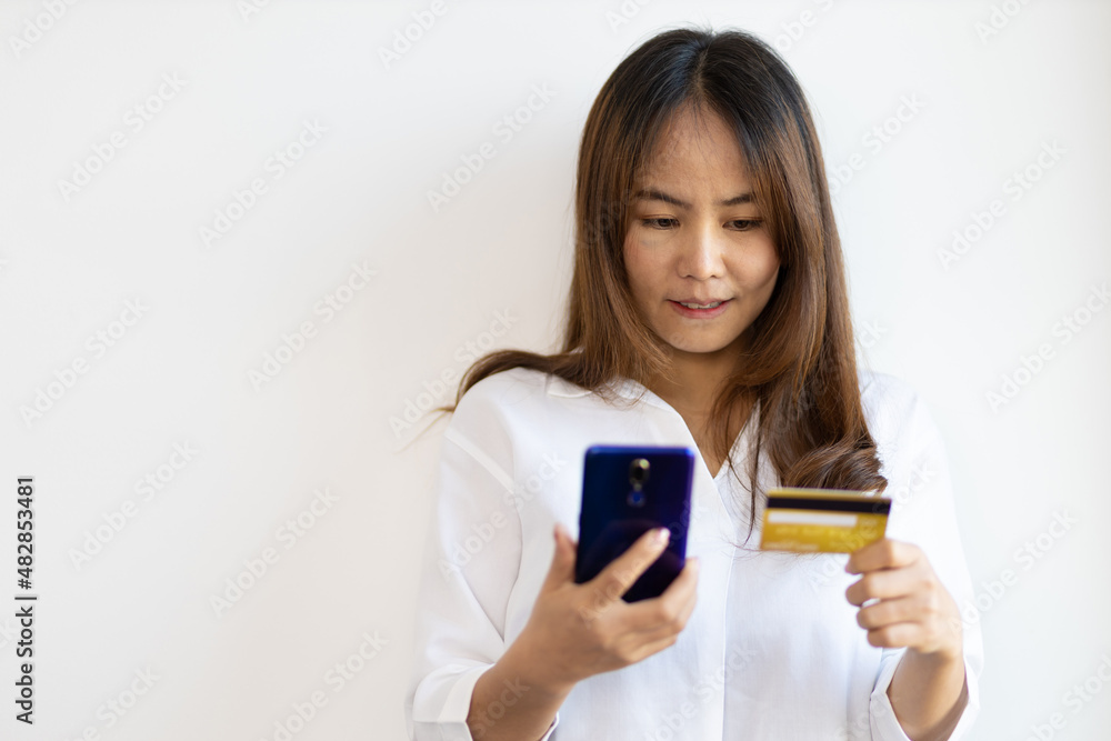 Asian woman holding credit card and using mobile phone. Asian woman holding credit card and using mobile phone.