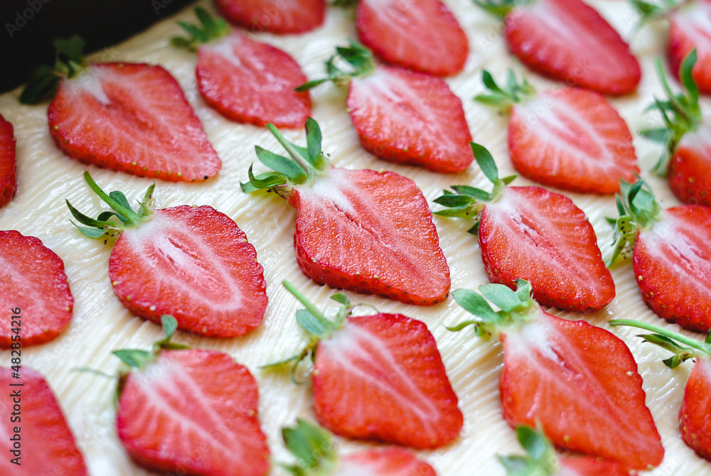 Many sliced strawberries on a light background Many sliced strawberries on a light background