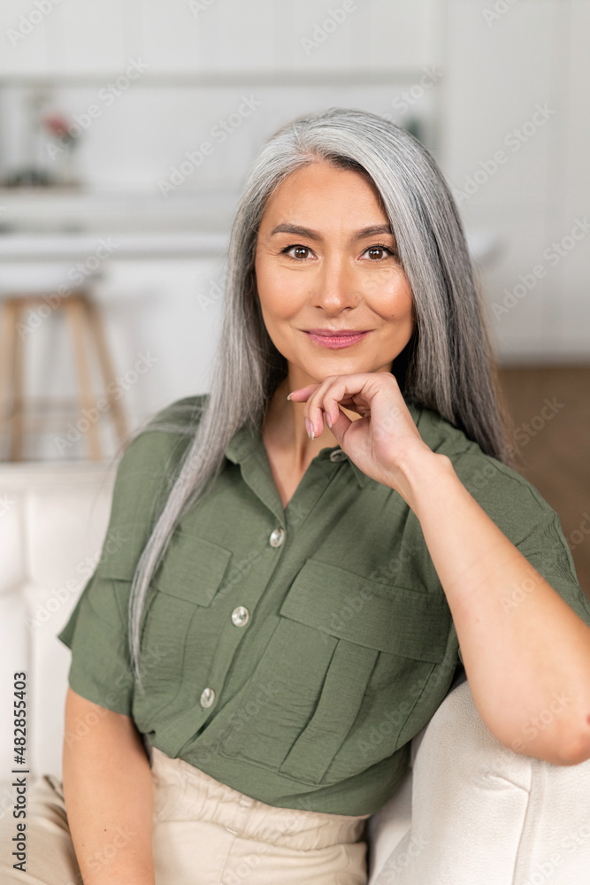 © Vadim Pastuh - Headshot of smiling good-looking senior Asian female looking at camera. Cheerful carefree grey-haired woman resting at home, vertical shot © Vadim Pastuh - Headshot of smiling good-looking senior Asian female looking at camera. Cheerful carefree grey-haired woman resting at home, vertical shot