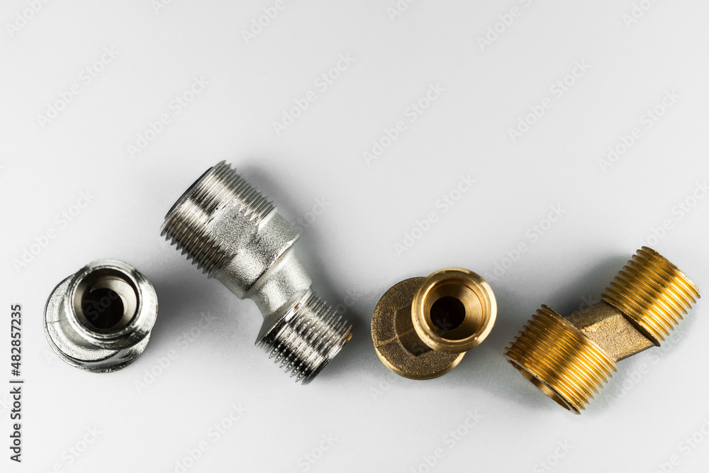 Two pairs of eccentrics connectors in brass and stainless steel. Eccentric mixer adapter faucet. On a light background.. Two pairs of eccentrics connectors in brass and stainless steel. Eccentric mixer adapter faucet. On a light background..