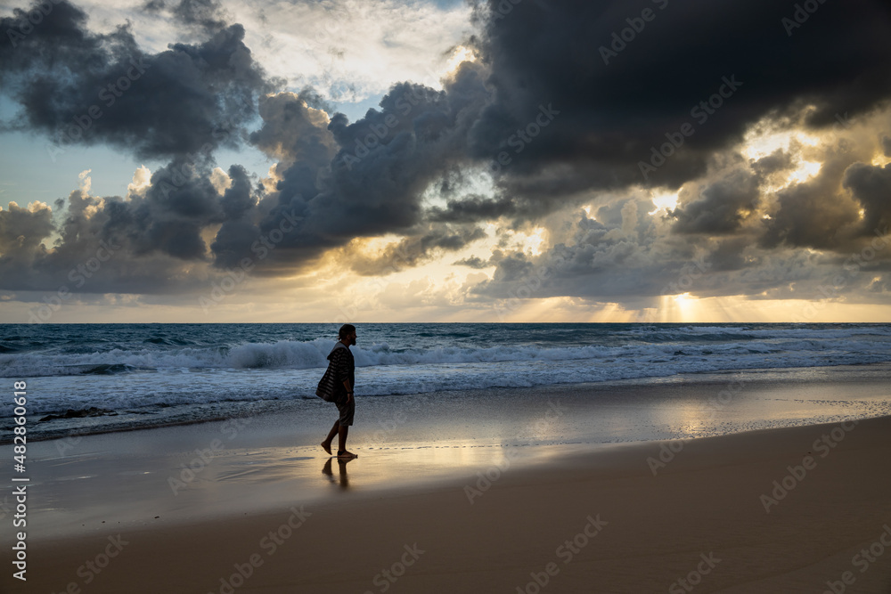 Naklejka premium Silhouette of a man jumping with happiness on the beach on vacation.