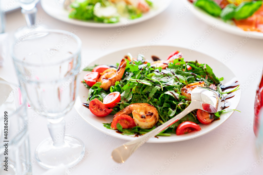 salad of arugula lettuce, tomatoes and shrimp.