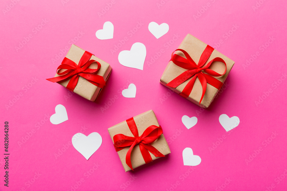 Valentine day composition Background: red gift box with bow and heart. Christmas present. View from above. Holday greeting card Valentine day composition Background: red gift box with bow and heart. Christmas present. View from above. Holday greeting card