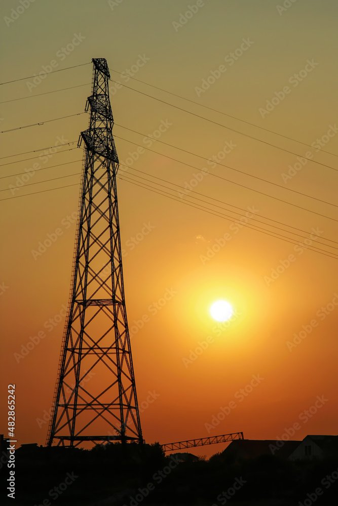 Sunset behind electricity pole in town
