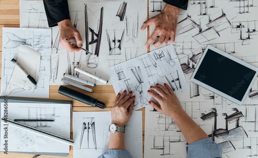 Table Top View of Furniture Designer Team Hands Drawing Blueprint