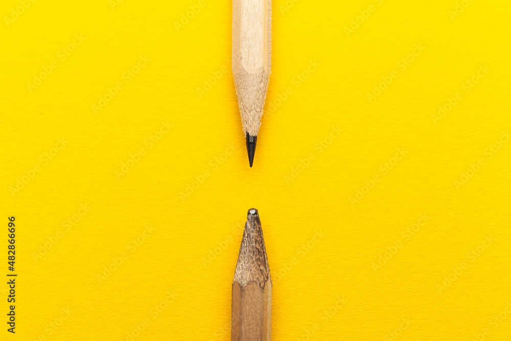 Scribbled and new pencil on a yellow background. Experienced and inexperienced. - obrazy, fototapety, plakaty 