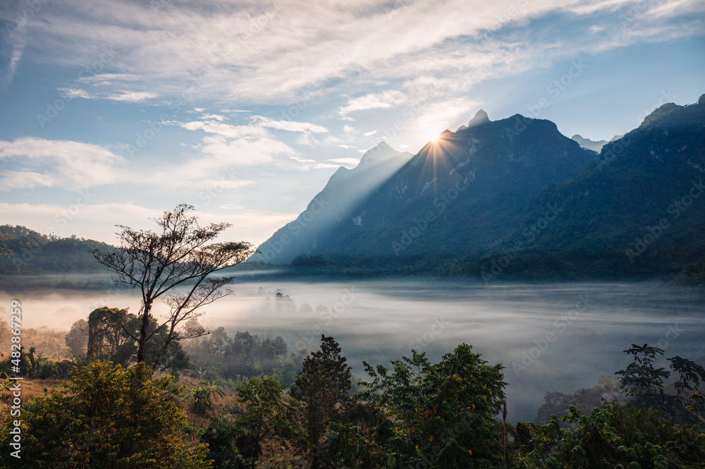 Scenery of sunrise over mountain range with foggy in tropical rainforest at national park