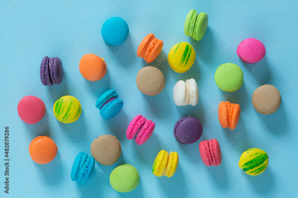 Cake macaron or macaroon on turquoise background from above, colorful almond cookies, pastel colors, vintage card, top view Cake macaron or macaroon on turquoise background from above, colorful almond cookies, pastel colors, vintage card, top view