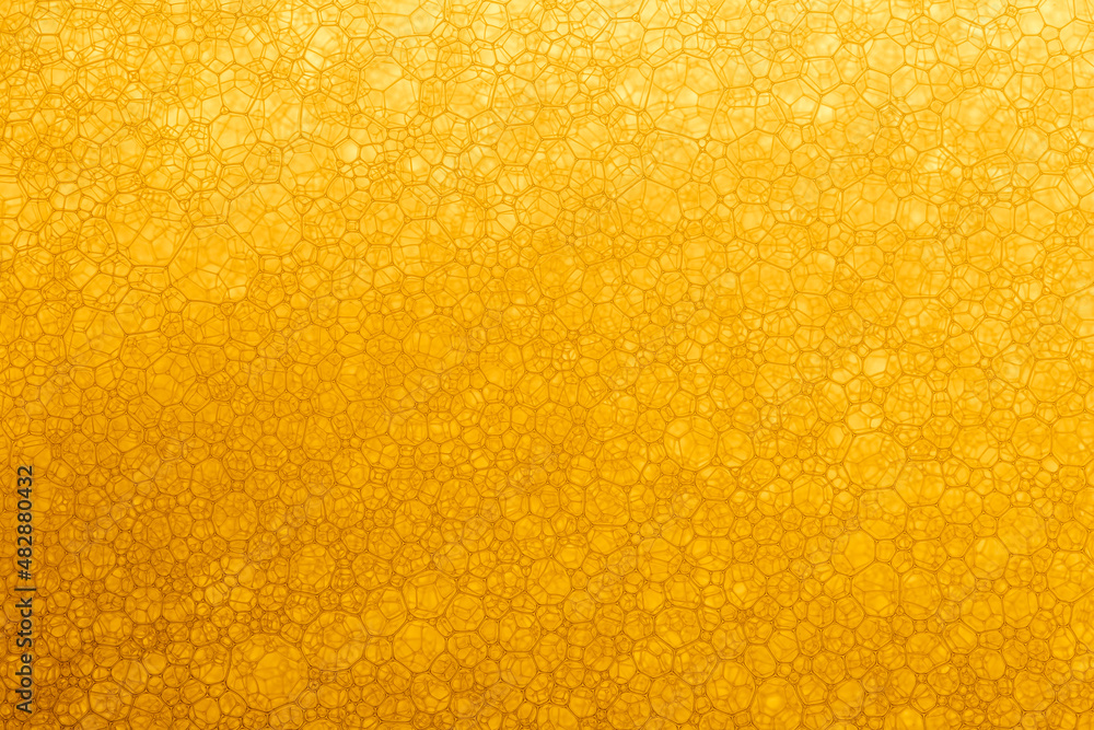 Abstract colorful background. Foam of Soap with Bubbles macro shot. Closeup bubbles in water. Oil drops on a water surface abstract background. Golden yellow bubble.Yellow water bubbles wallpape