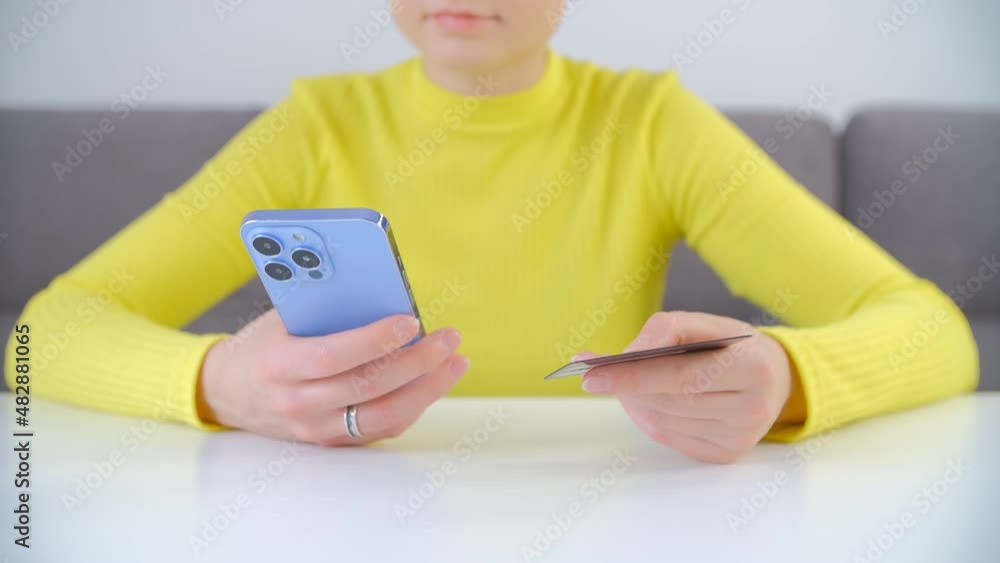 Buying with credit card. Woman paying online with smart phone. Female making a money transfer with mobile phone in closeup 4k video. Buyer shopping online with cellphone gadget