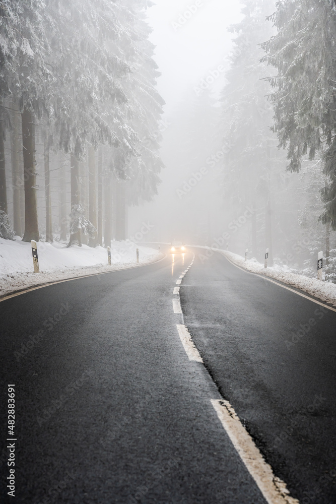 Fototapeta premium car driving on winter mountain road