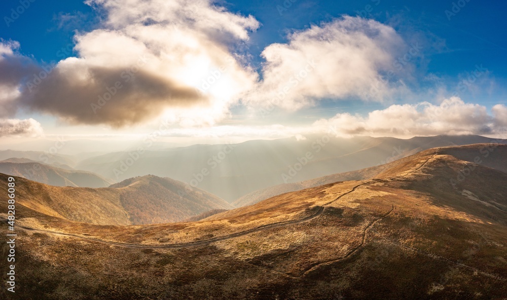 Fototapeta premium Long pathways running along mountains under blue sky