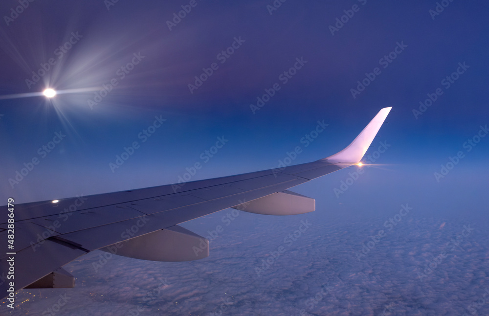 Obraz premium Aircraft wing in flight seen from inside. above the clouds.