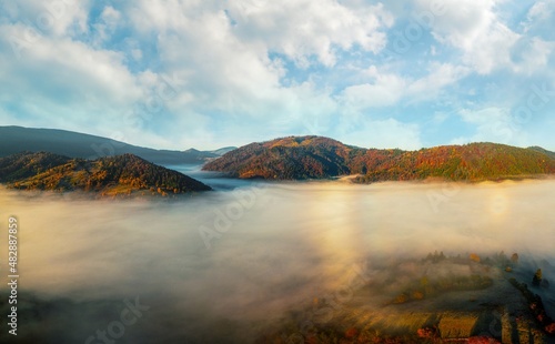 Fototapeta Naklejka Na Ścianę i Meble -  Thick layer of fog covering rainbow mountains with colorful trees