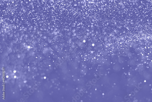 Very peri color of the year 2022, violet sparkling glitter bokeh background, christmas abstract defocused texture. Holiday lights