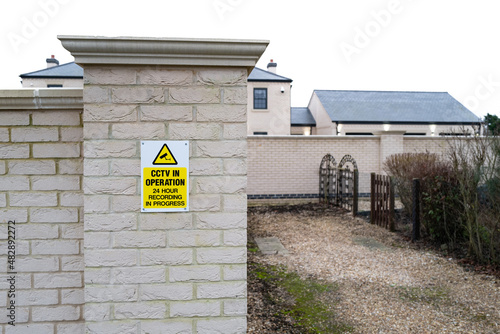 Newly installed CCTV Warning sign attached to a pillar outside a newly built mansion property. © Nick Beer