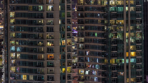 Night view of glowing windows in apartment building timelapse.