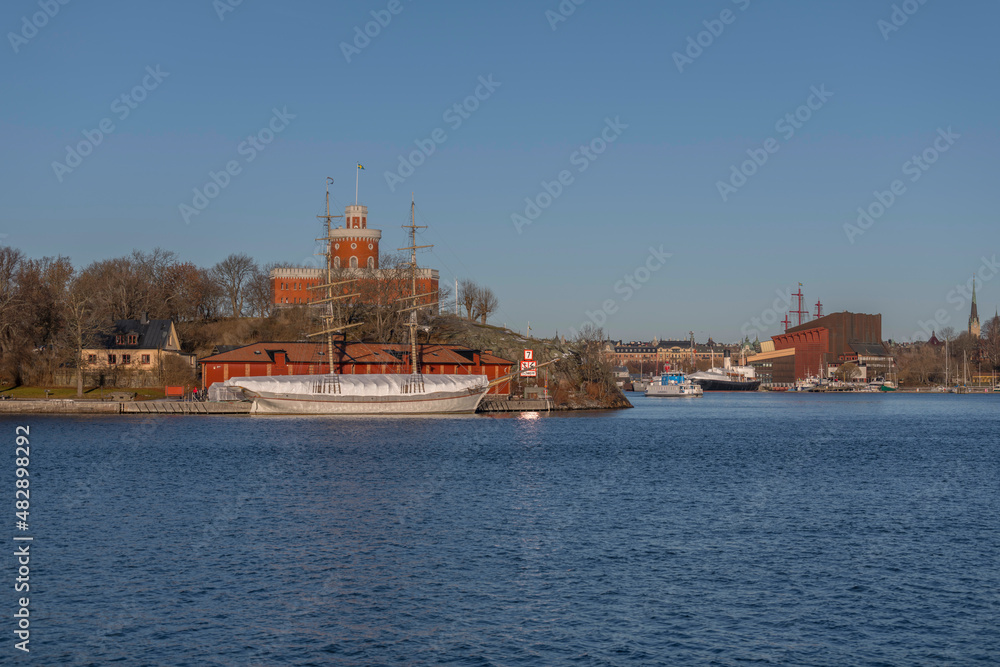 Panorama view over the island Kastellholmen with a castell and the skyline of the amusement park towers and the ship yard Beckholmen a sunny winter day in Stockholm