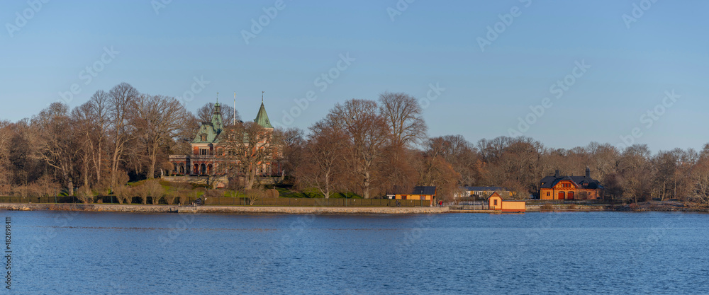 Panorama view of the ness Täcka udden and an old 1700:s castle looking villa on the island Djurgården a sunny winter day in the archipelago of Stockholm